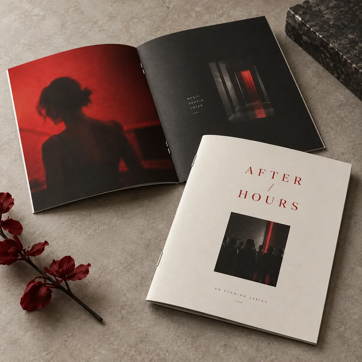 Printed booklets shown as a physical product in charcoal, red and warm white