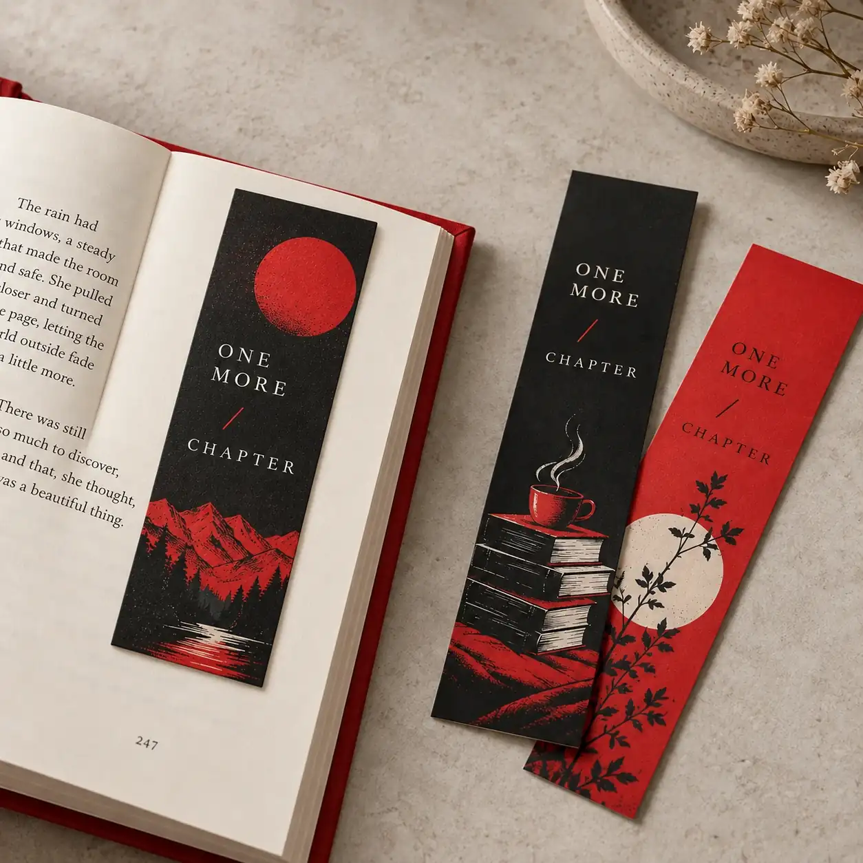 Red and charcoal bookmarks, with one resting naturally on top of an intact open book page