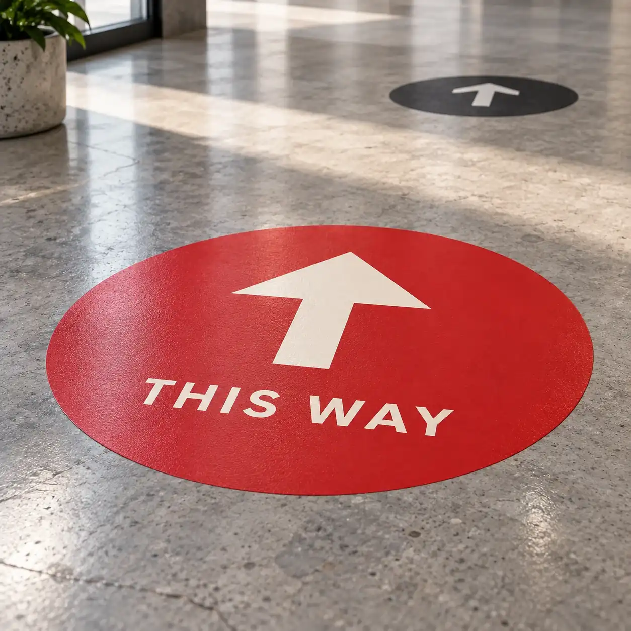 Printed floor graphics shown as a physical product in charcoal, red and warm white