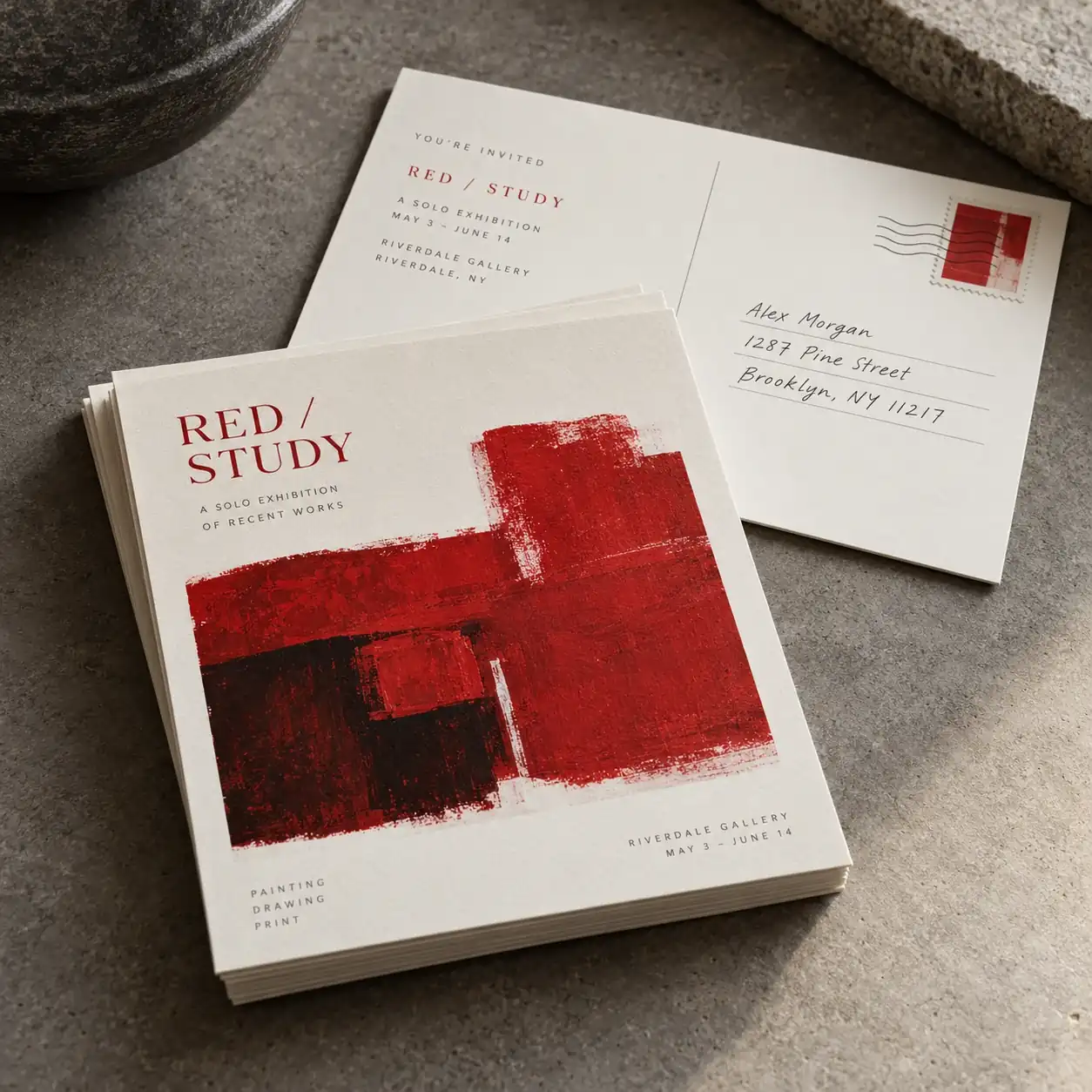 Printed postcards shown as a physical product in charcoal, red and warm white