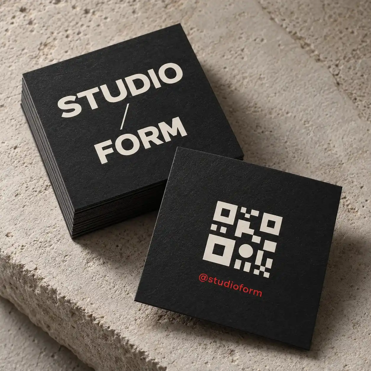 Printed social cards shown as a physical product in charcoal, red and warm white