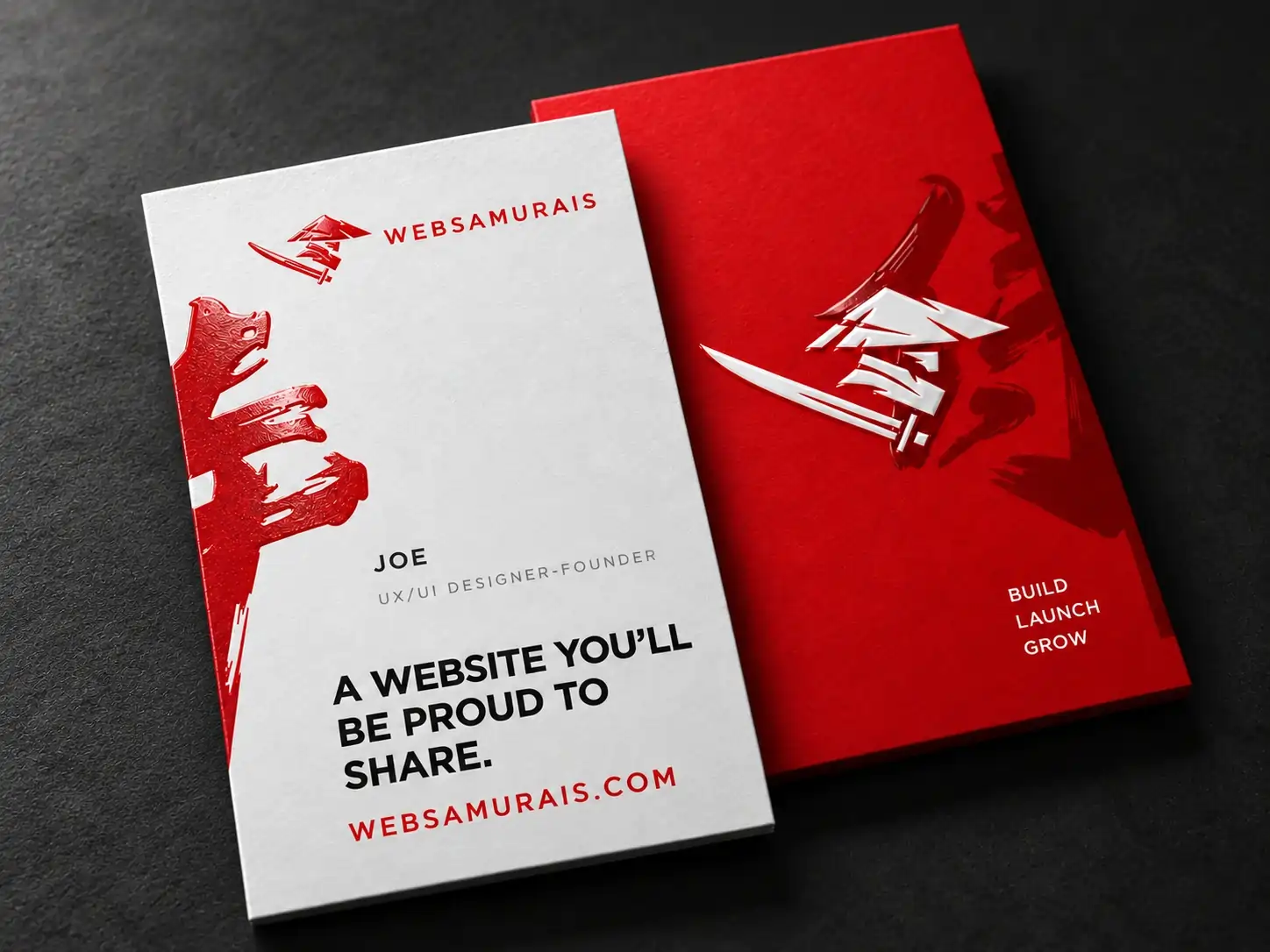 White and red Web Samurais business cards on a charcoal surface